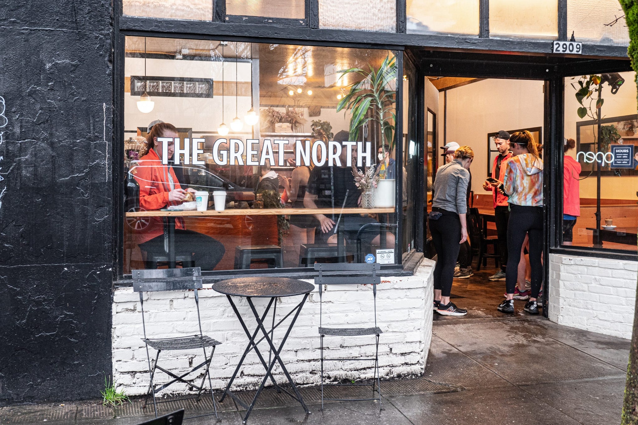 The Great North storefront with a large window and customers inside while others stand outside.