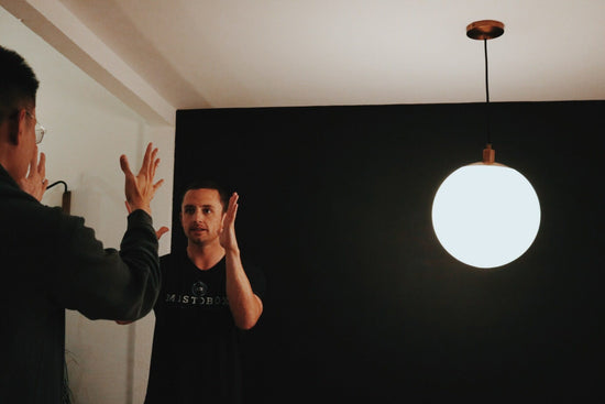 Two men on a studio set high five during the Natfluence interview with Connor Riley