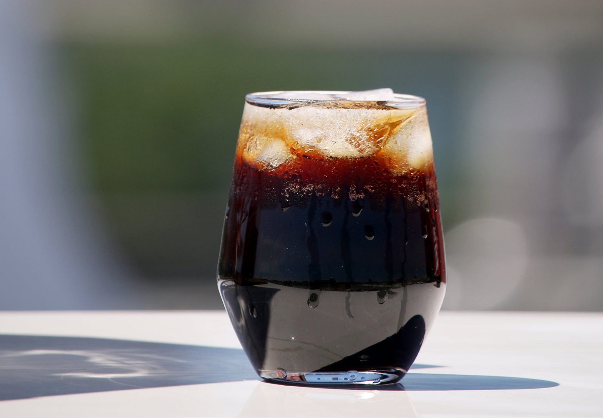 Glass of iced coffee with ice cubes and condensation