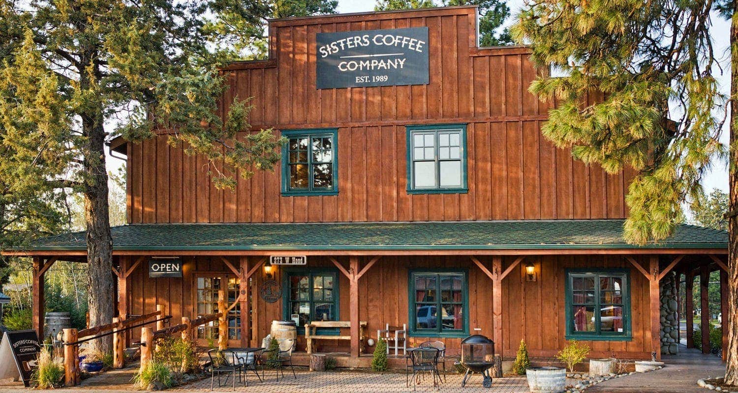 Sisters Coffee Company storefront on a rustic wooden building with outdoor seating